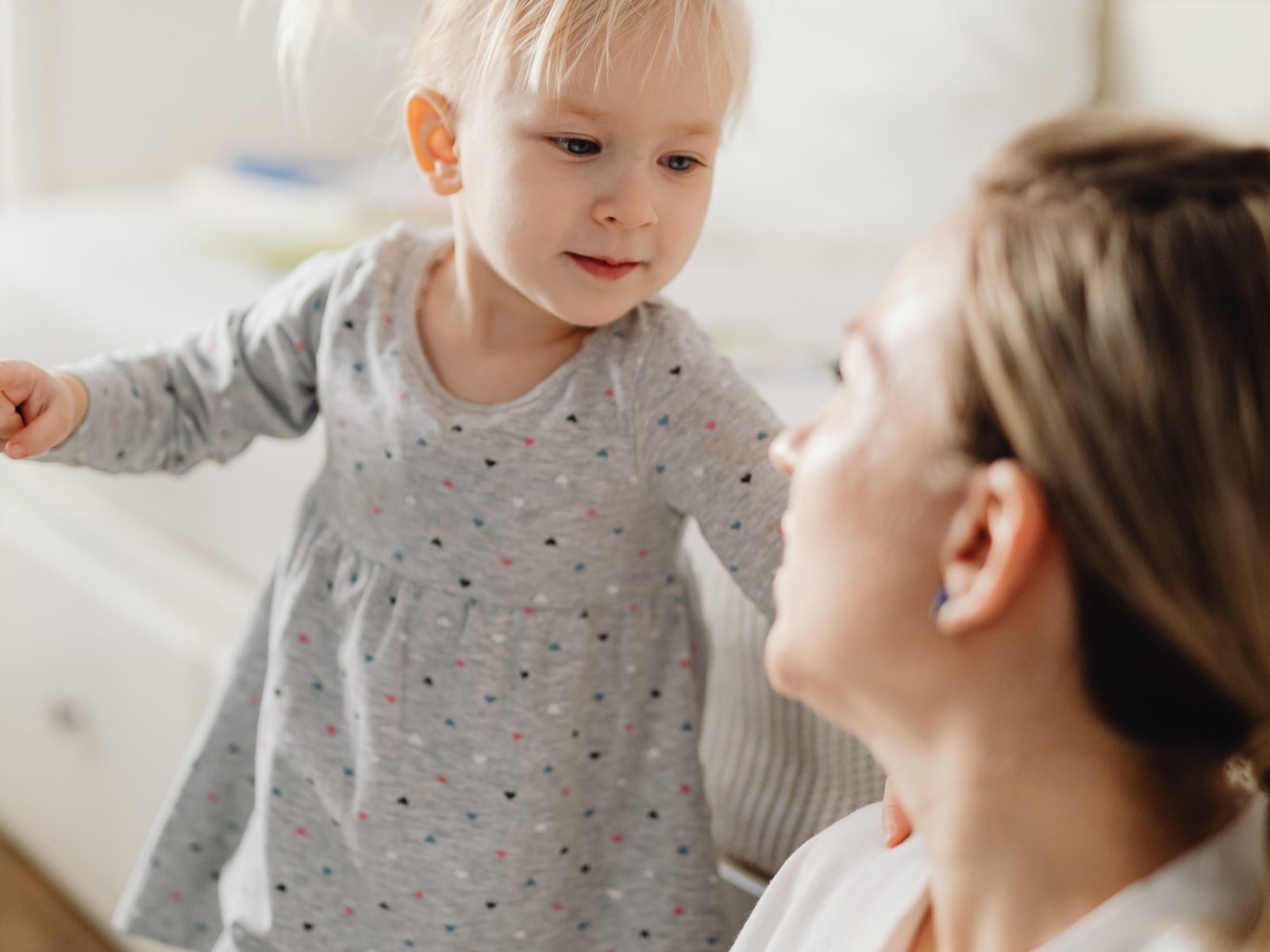 Eine Mutter schaut ihre Tochter aufmerksam an, die vor ihr steht