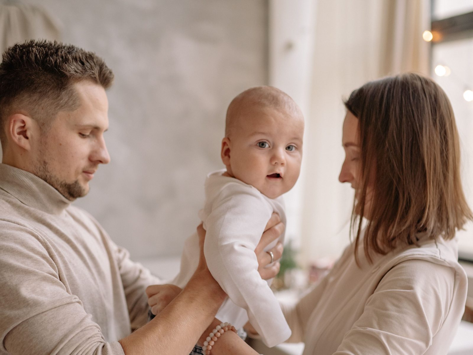 Eine Mutter und ein Vater halten gemeinsam ihr Baby zwischen sich
